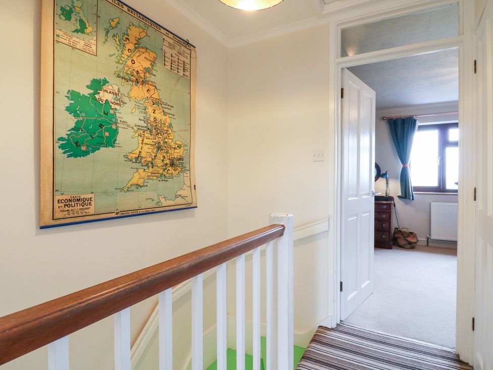 A hallway with a map on the wall and a door leading to another room at Coastguard Cottage Rye