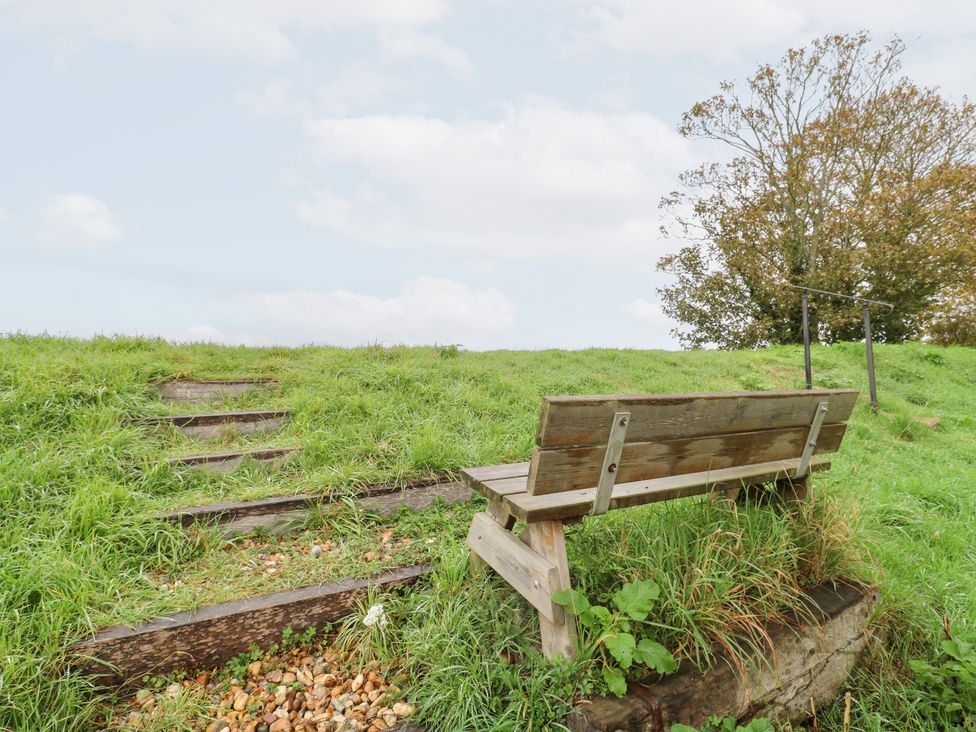 A bench near steps in a grassy area at Coastguard Cottage in Rye
