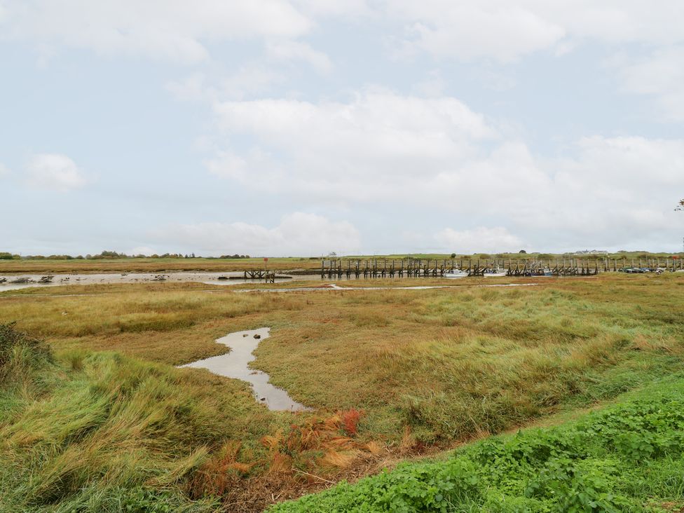 A view of a marsh with a dock and boats at Coastguard Cottage, Rye