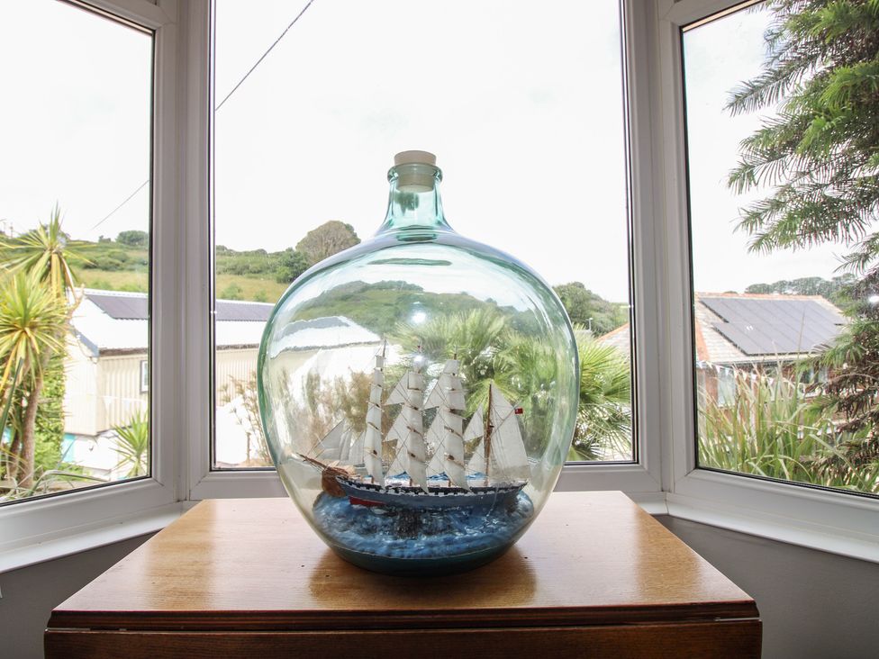 A ship in a bottle on a cabinet with a view at Home in Salcombe