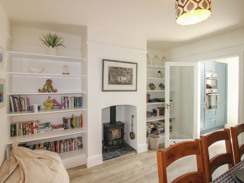 A living room with a bookshelf and fireplace at Home in Salcombe