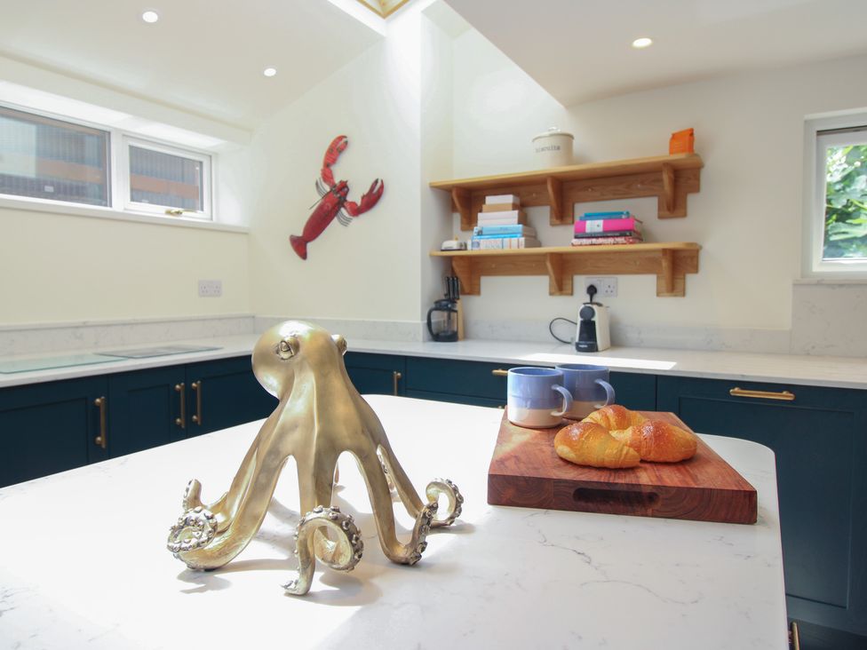 A kitchen with an octopus sculpture, croissant, and mugs at Home in Salcombe