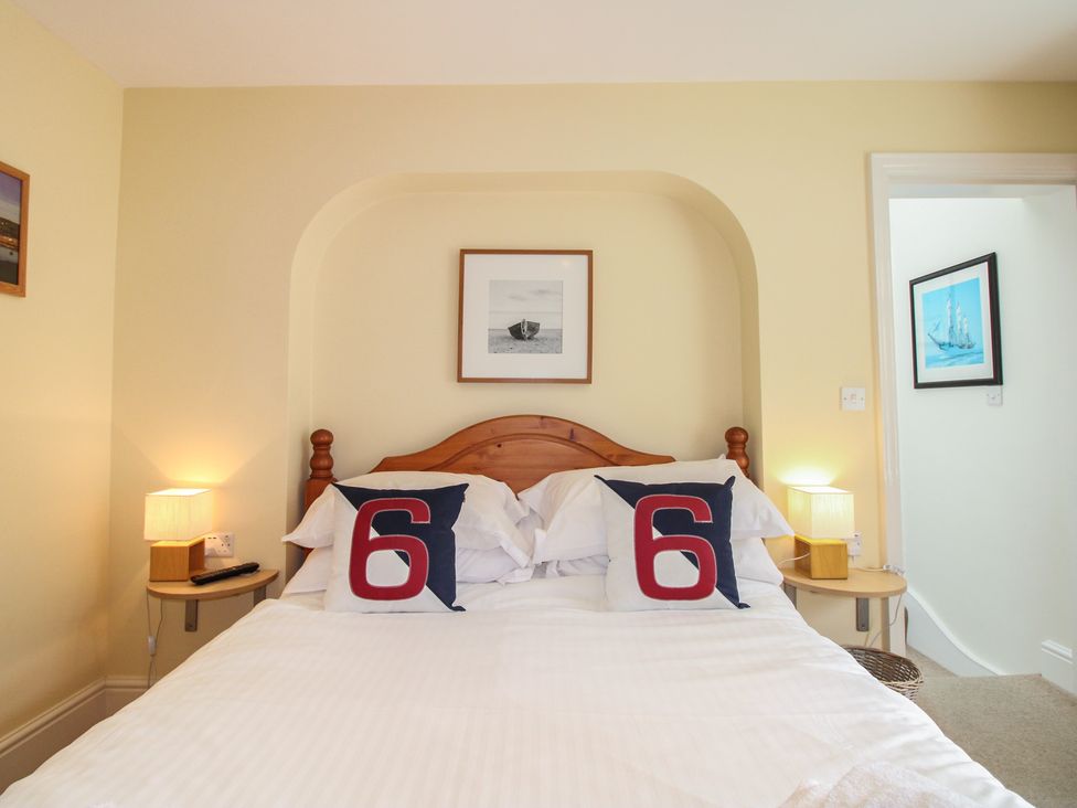 A bedroom with a bed and artwork at Home in Salcombe