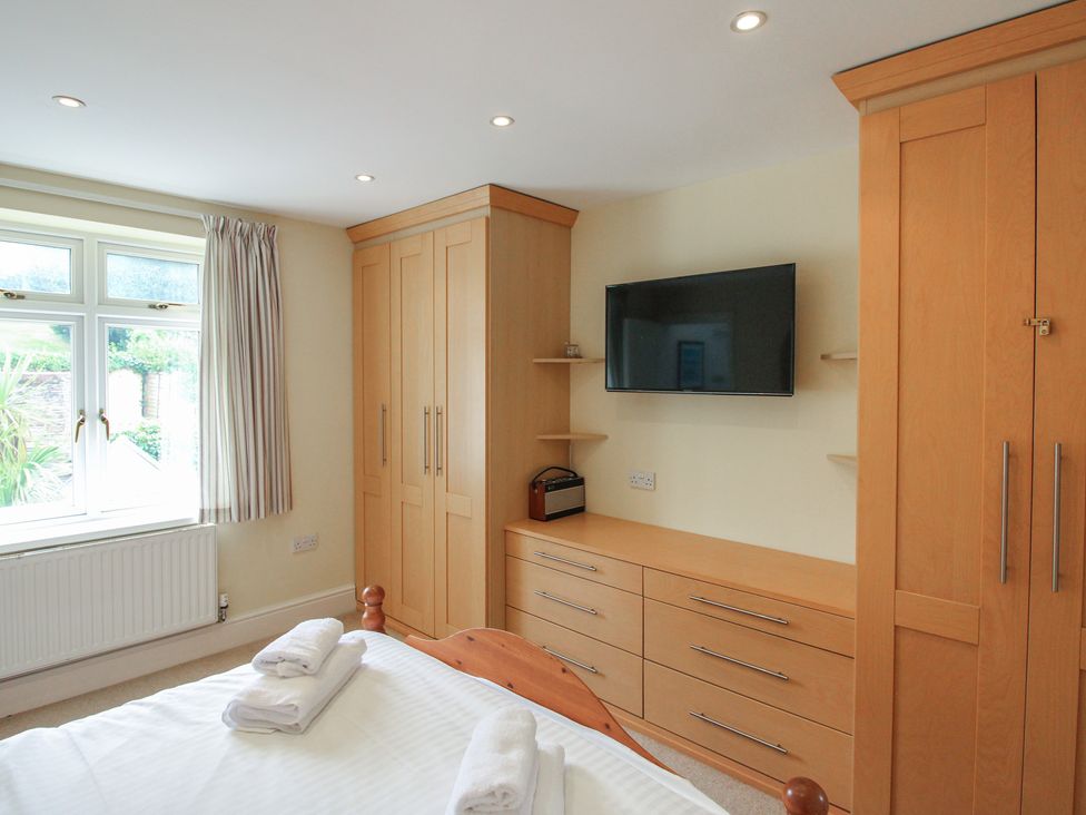 A bedroom with a wardrobe and television at Home in Salcombe