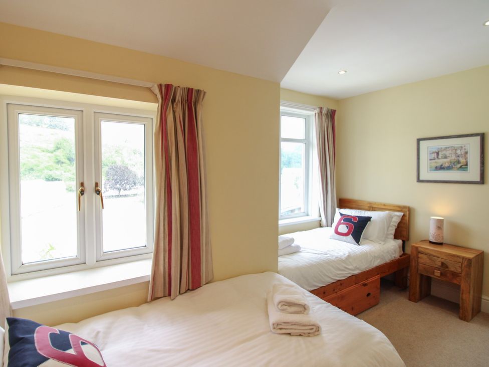 A bedroom with two beds and a window at Home in Salcombe