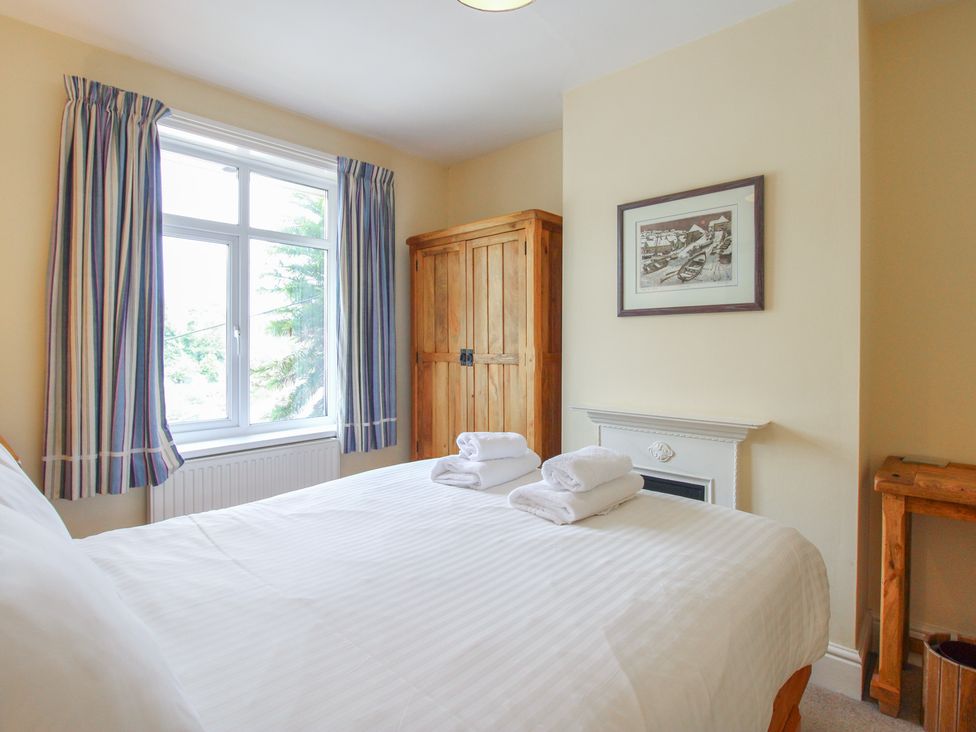 A bedroom with a bed and wardrobe at Home in Salcombe