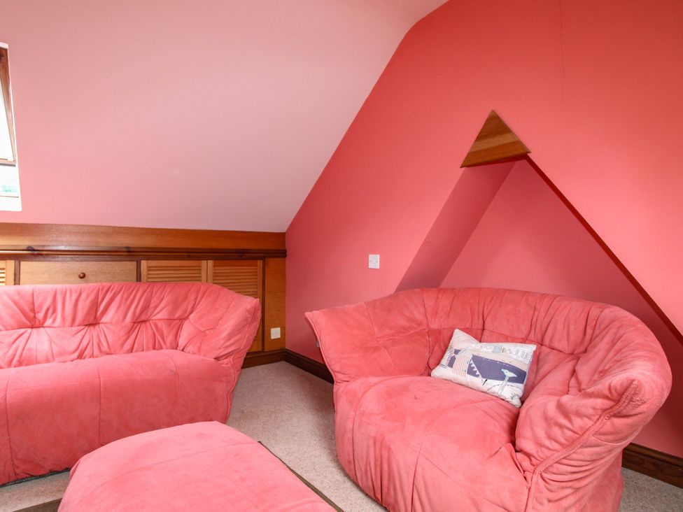 A living room with pink sofas and a window at Home in Salcombe