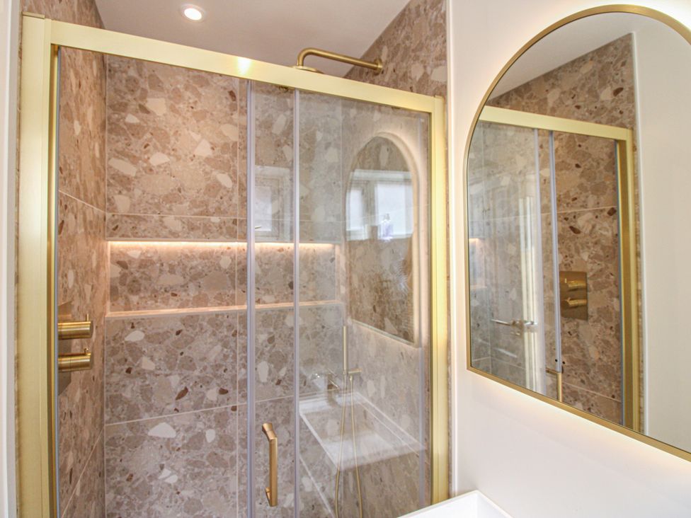 A bathroom with a shower and mirror at Home in Salcombe