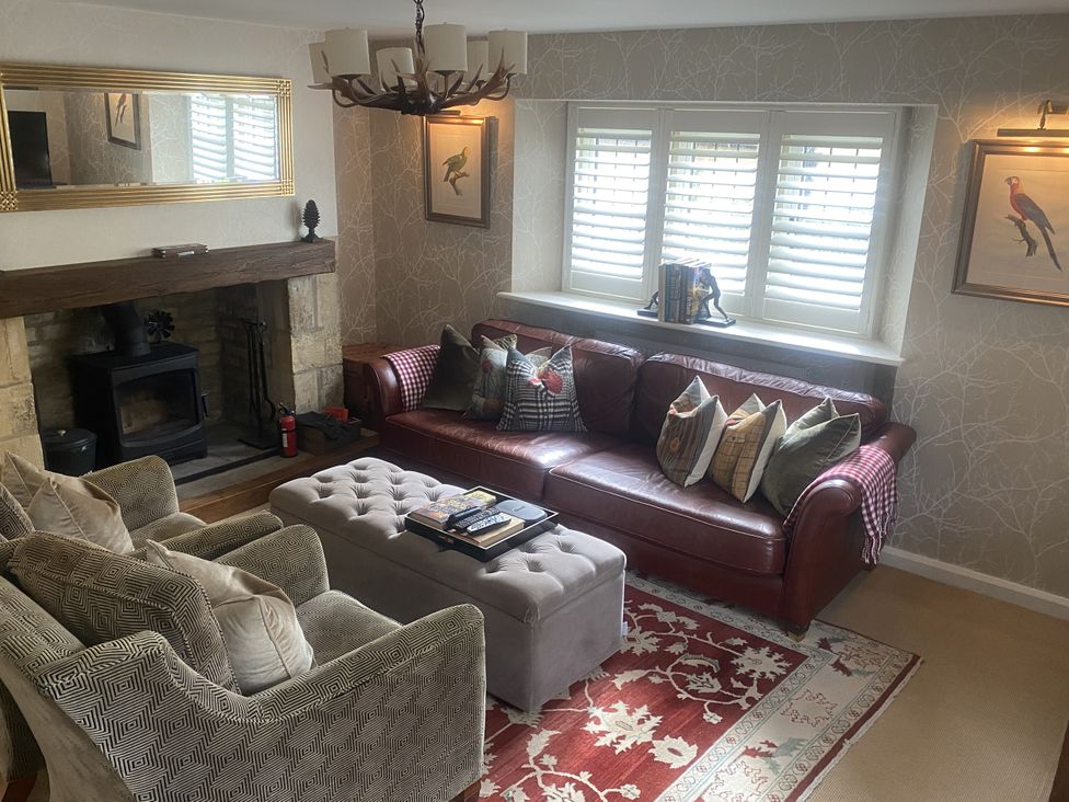 A living room with a fireplace and seating area at Mill Stream Cottage Lower Slaughter near Bourton-On-The-Water