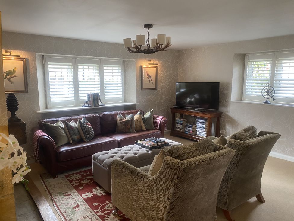 A living room with a sofa and television at Mill Stream Cottage Lower Slaughter near Bourton-On-The-Water
