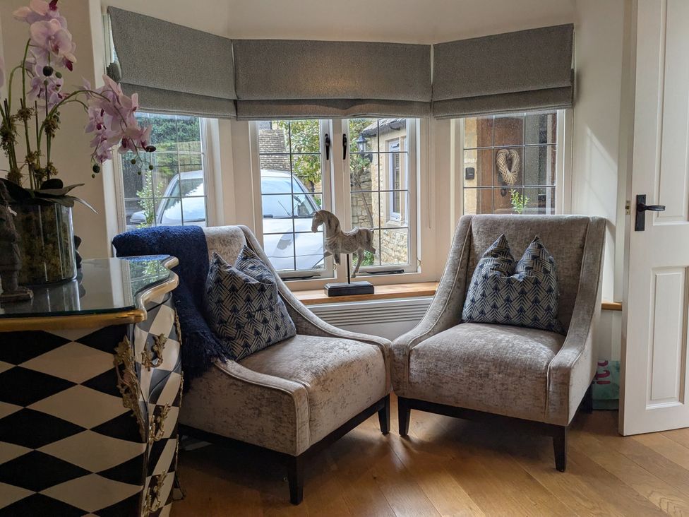 A sitting room with two chairs and a table at Mill Stream Cottage in Lower Slaughter near Bourton-On-The-Water