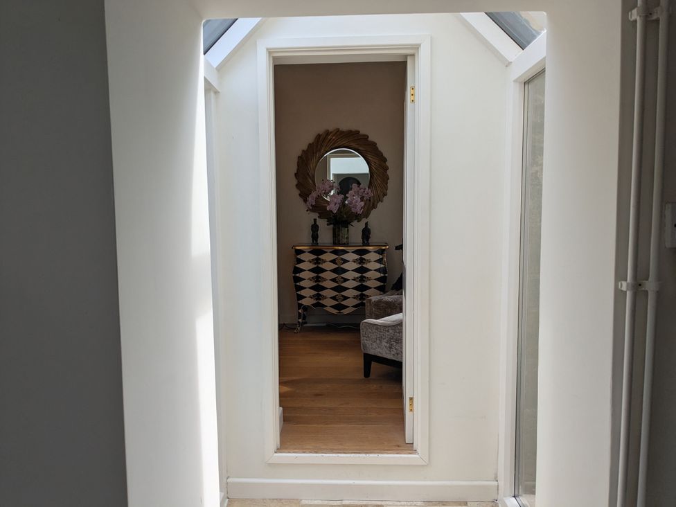 A hallway with a console table and a mirror at Mill Stream Cottage Lower Slaughter near Bourton-On-The-Water