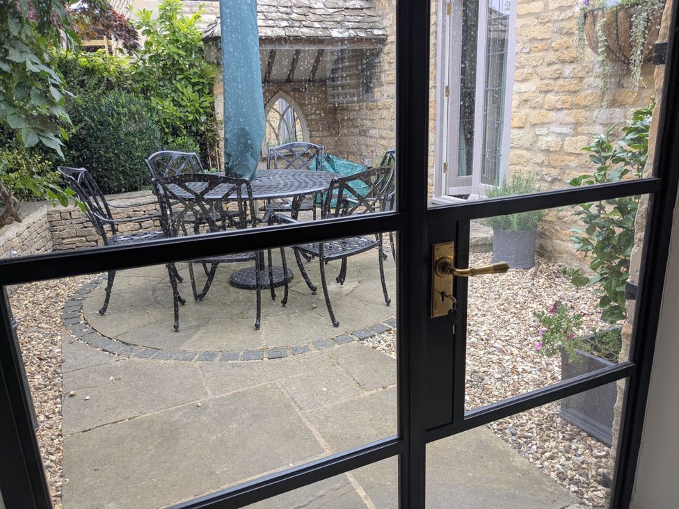 An outdoor area with a table and chairs at Mill Stream Cottage in Lower Slaughter near Bourton-On-The-Water