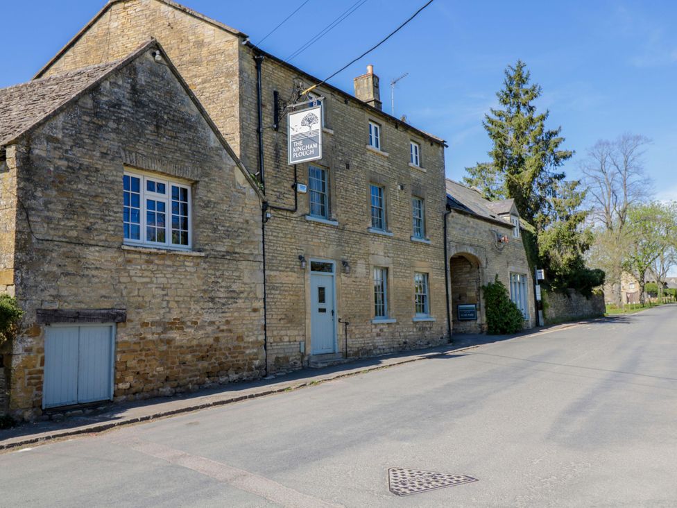 A stone building with a sign on the exterior at The Tap Room in Kingham