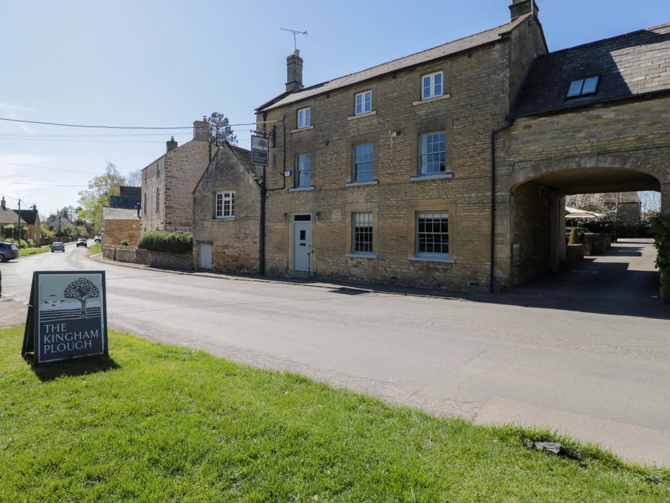 A building exterior featuring a sign at The Kinham Plough in Kingham