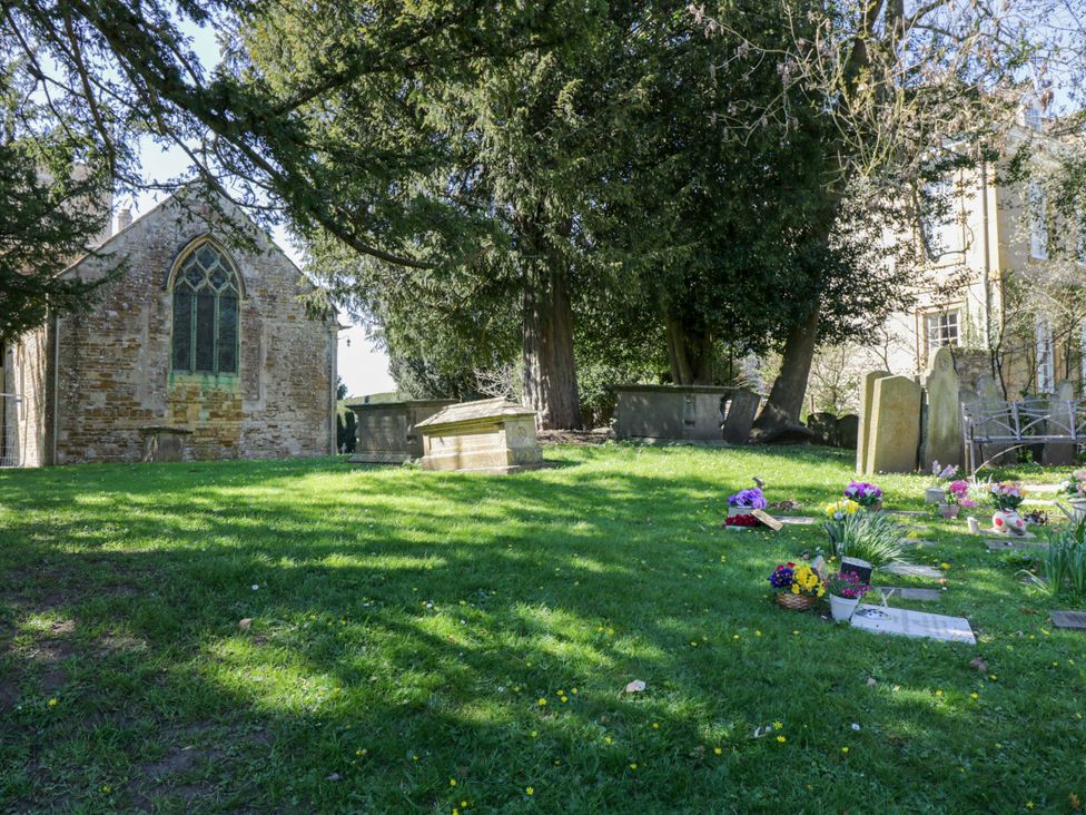 A graveyard with a church and flowers at The Tap Room in Kingham