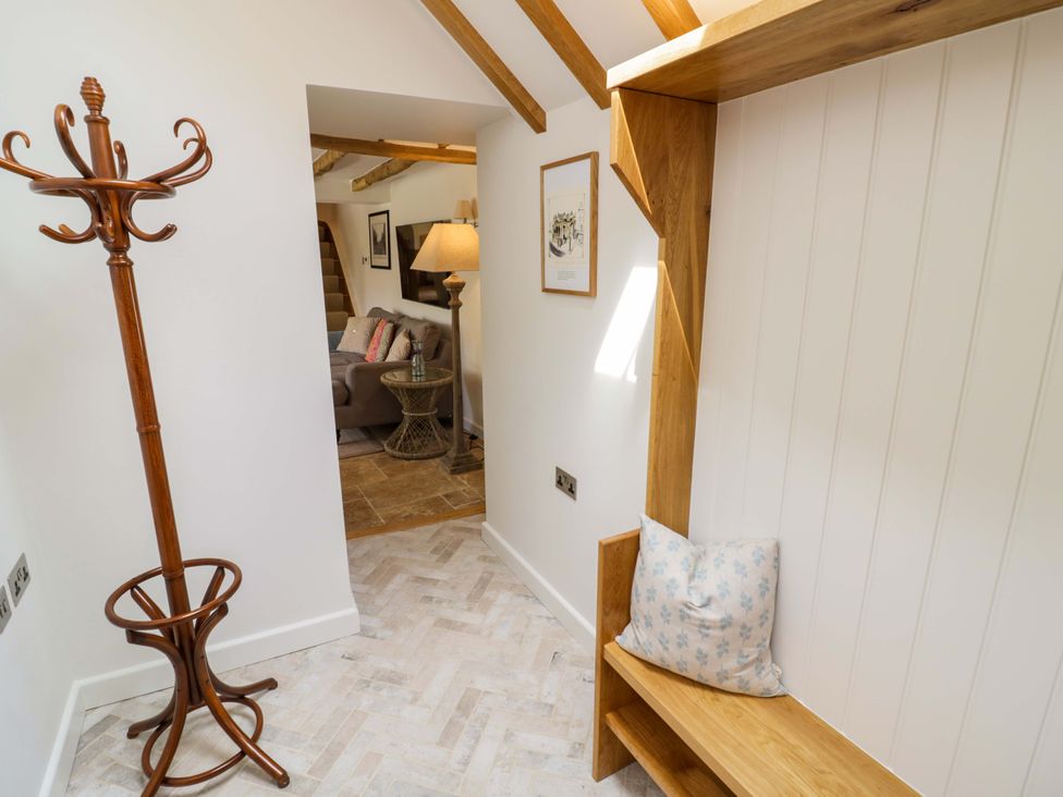 A hallway with a coat rack, bench, and lamp at Wyncliffe in Chipping Campden