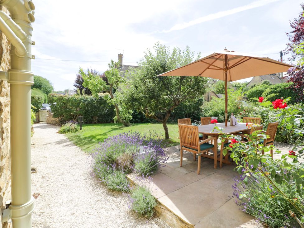 A garden with a table and chairs under an umbrella at Wyncliffe in Chipping Campden