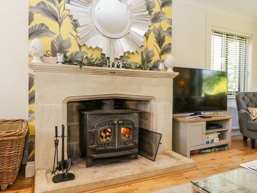 A living room with a fireplace and television at Bell Garden in Stow-On-The-Wold