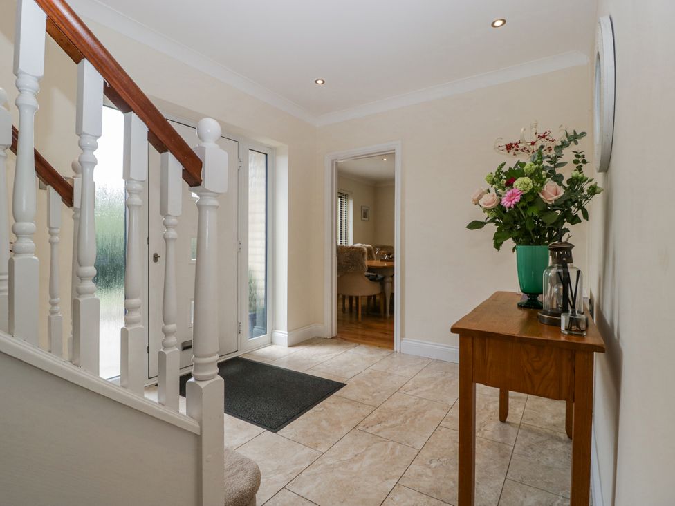 A hallway with a staircase and flower arrangement at Bell Garden in Stow-On-The-Wold