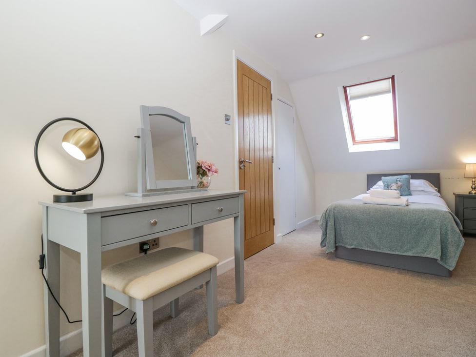 A bedroom with a bed and a vanity space at Bell Garden in Stow-On-The-Wold