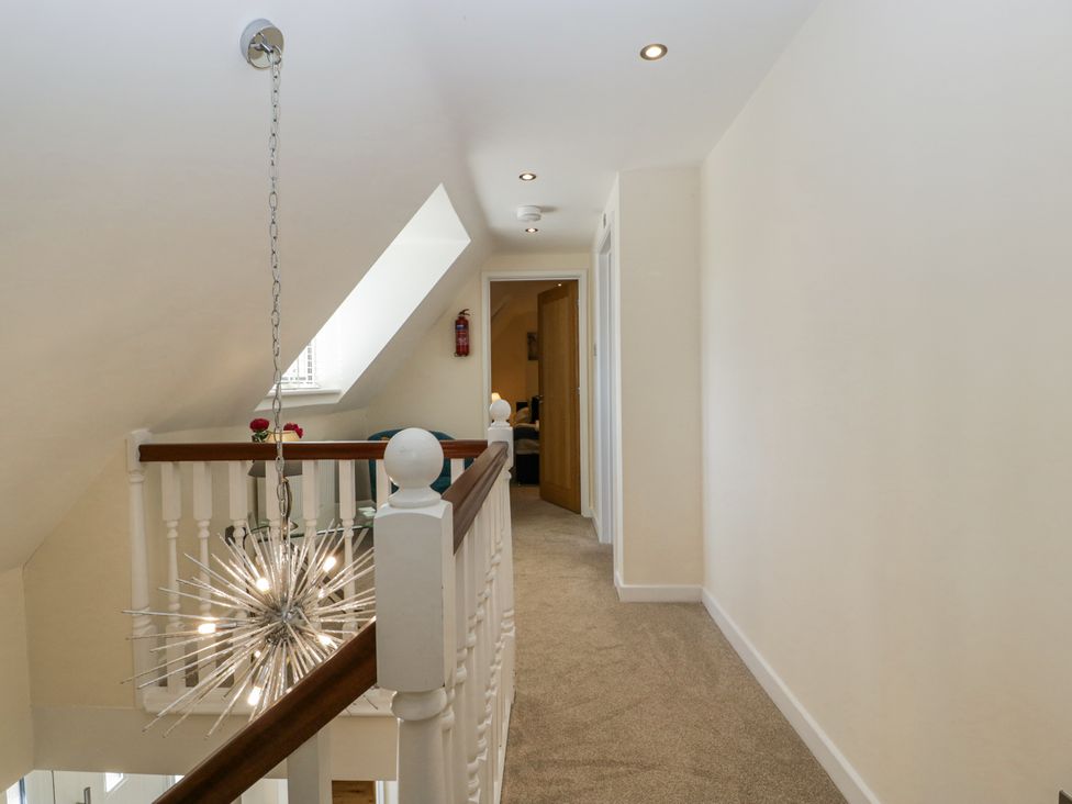 A hallway with a light fixture and carpet at Bell Garden in Stow-On-The-Wold