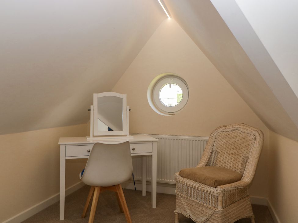 An attic space with a vanity table and a chair at Bell Garden in Stow-On-The-Wold