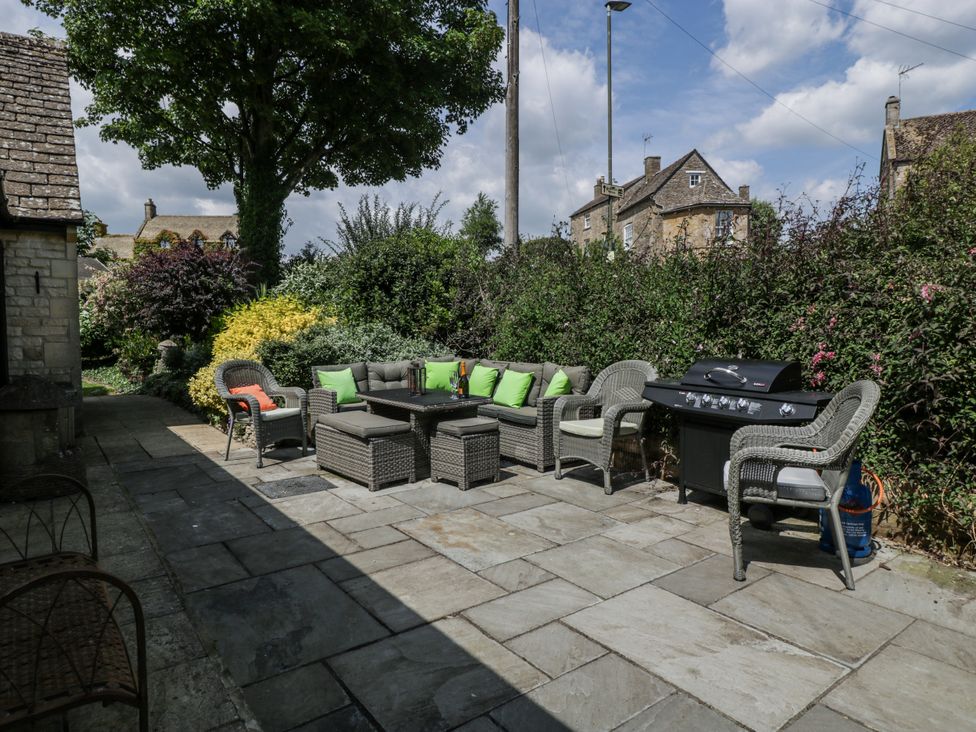 A garden with patio furniture and grill at Bell Garden in Stow-On-The-Wold