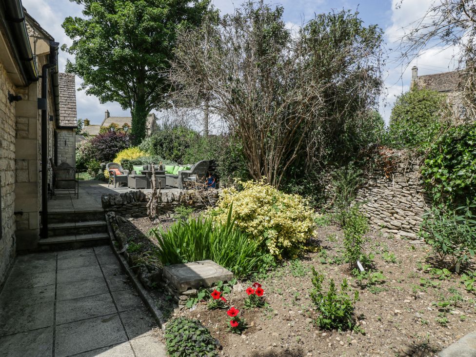 A garden with seating area and flowerbed at Bell Garden Stow-On-The-Wold