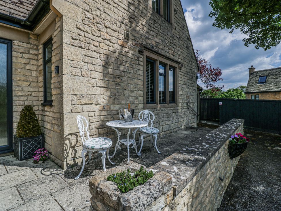 An outdoor seating area with a table and chairs at Bell Garden in Stow-On-The-Wold