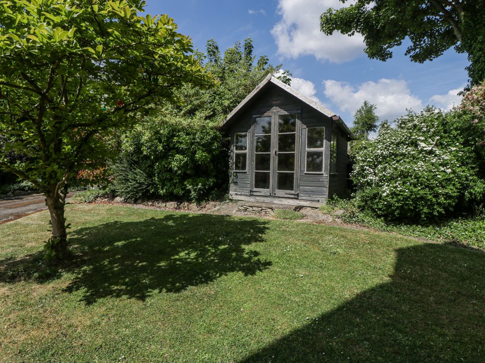 A garden with a shed surrounded by greenery at Bell Garden Stow-On-The-Wold