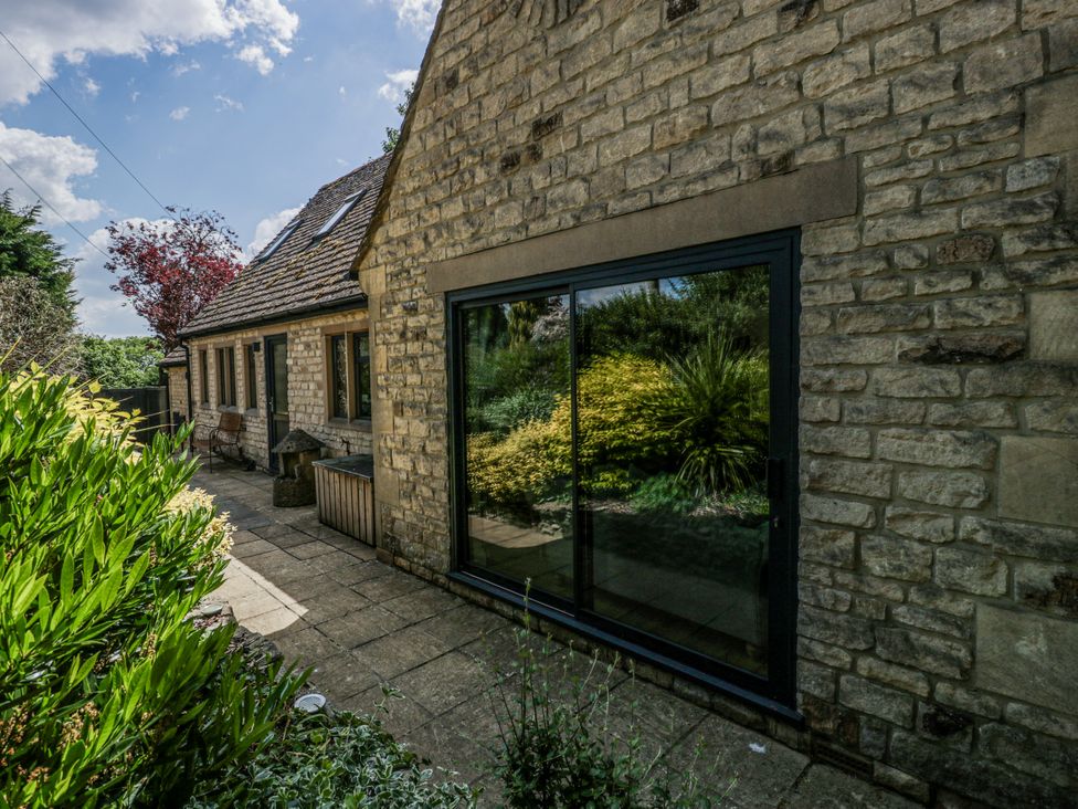 A garden with stone wall and windows at Bell Garden in Stow-On-The-Wold