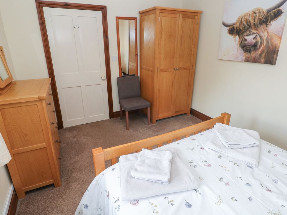 A bedroom with furniture including a bed and wardrobe at The Old Dairy in Maenclochog