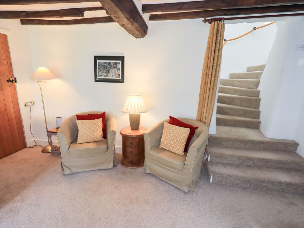 A living room with two chairs and a lamp at Burnside Cottage in Braithwaite