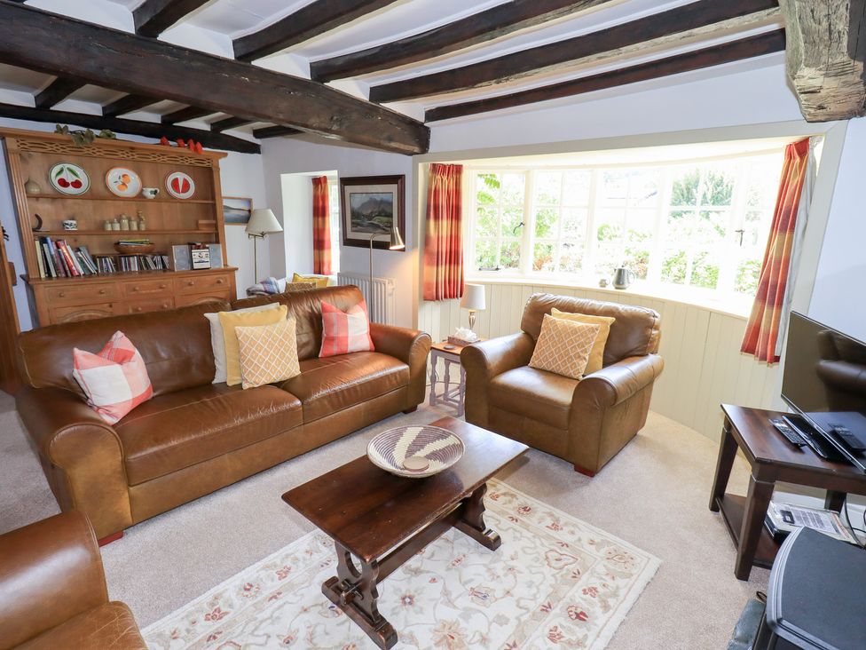 A living room with furniture and a window at Burnside Cottage in Braithwaite