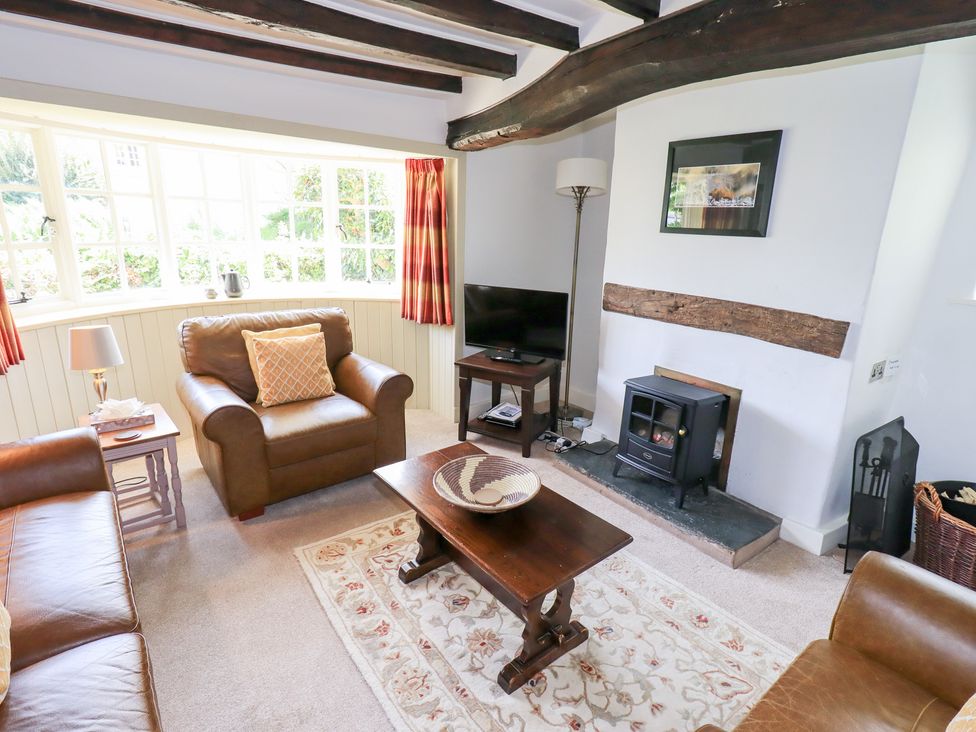 A living room with a tv and a coffee table at Burnside Cottage in Braithwaite