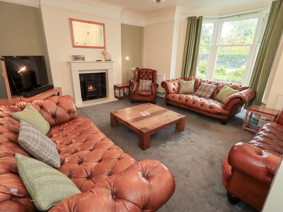 A living room with leather sofas and a coffee table at Hazelmere, Keswick