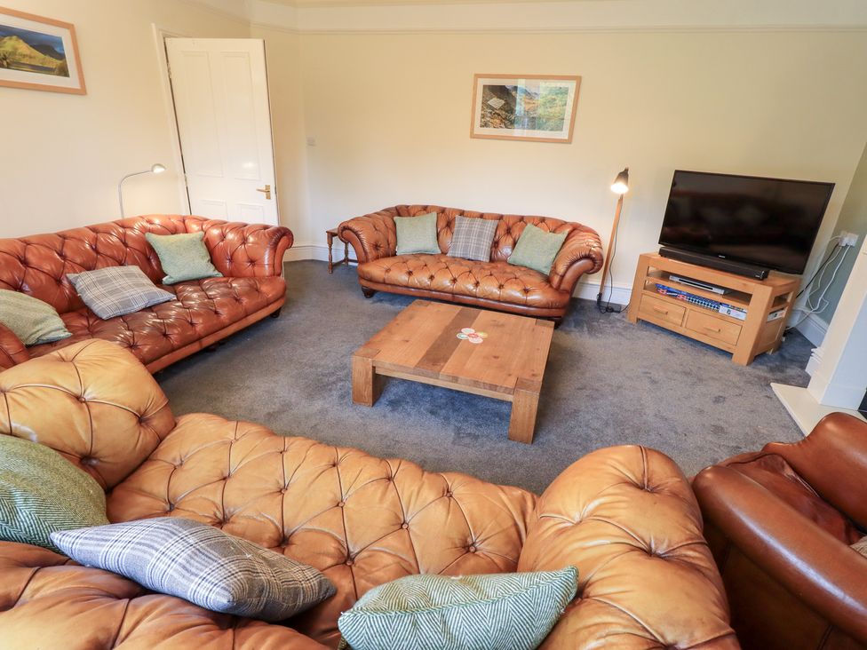 A living room with leather sofas and a wooden coffee table at Hazelmere in Keswick