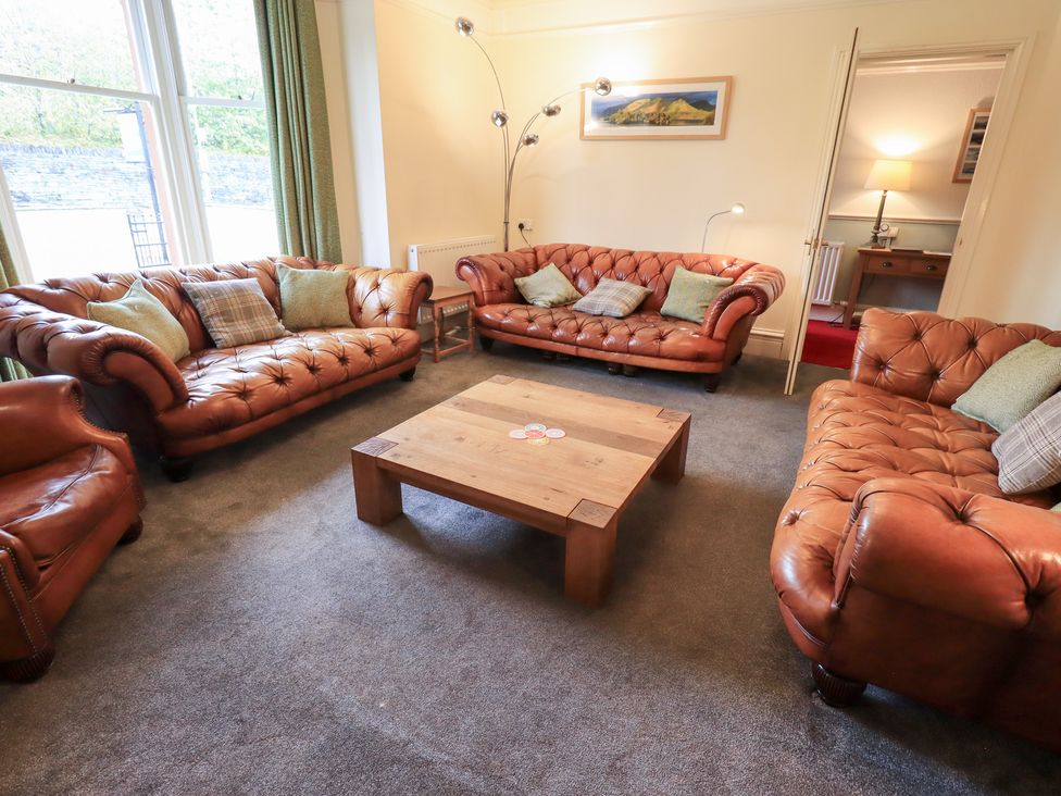 A living room with leather sofas and a coffee table at Hazelmere in Keswick
