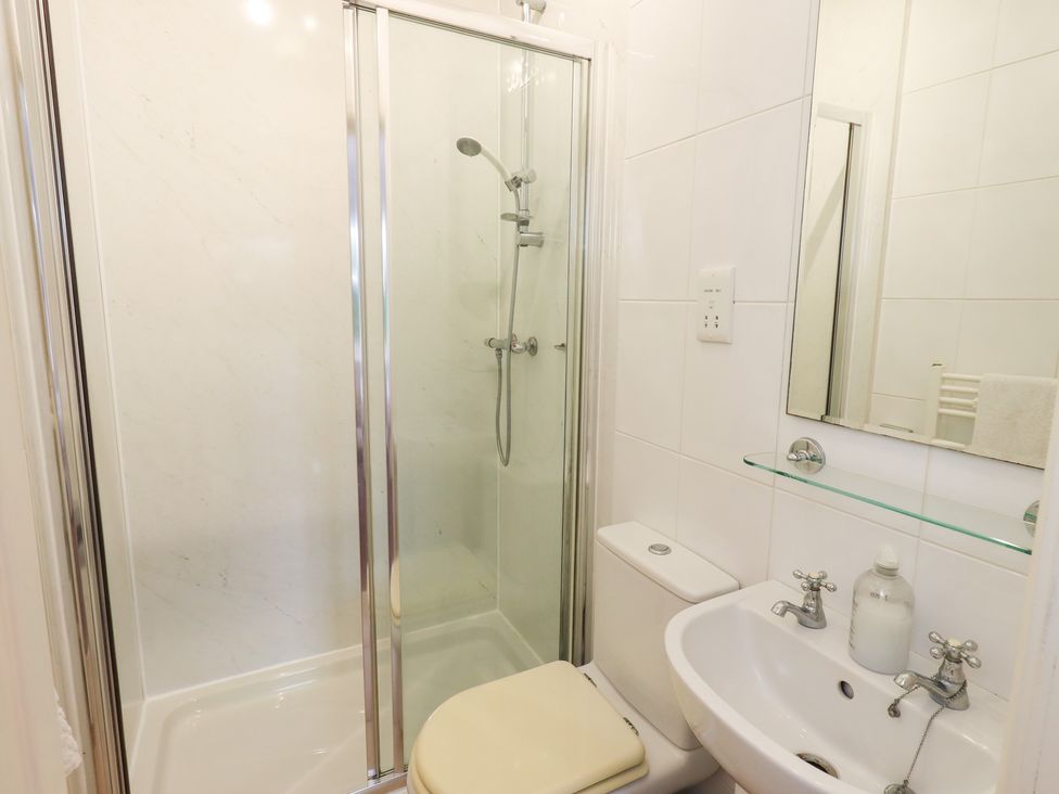 A bathroom with a shower, toilet, and sink at Hazelmere in Keswick