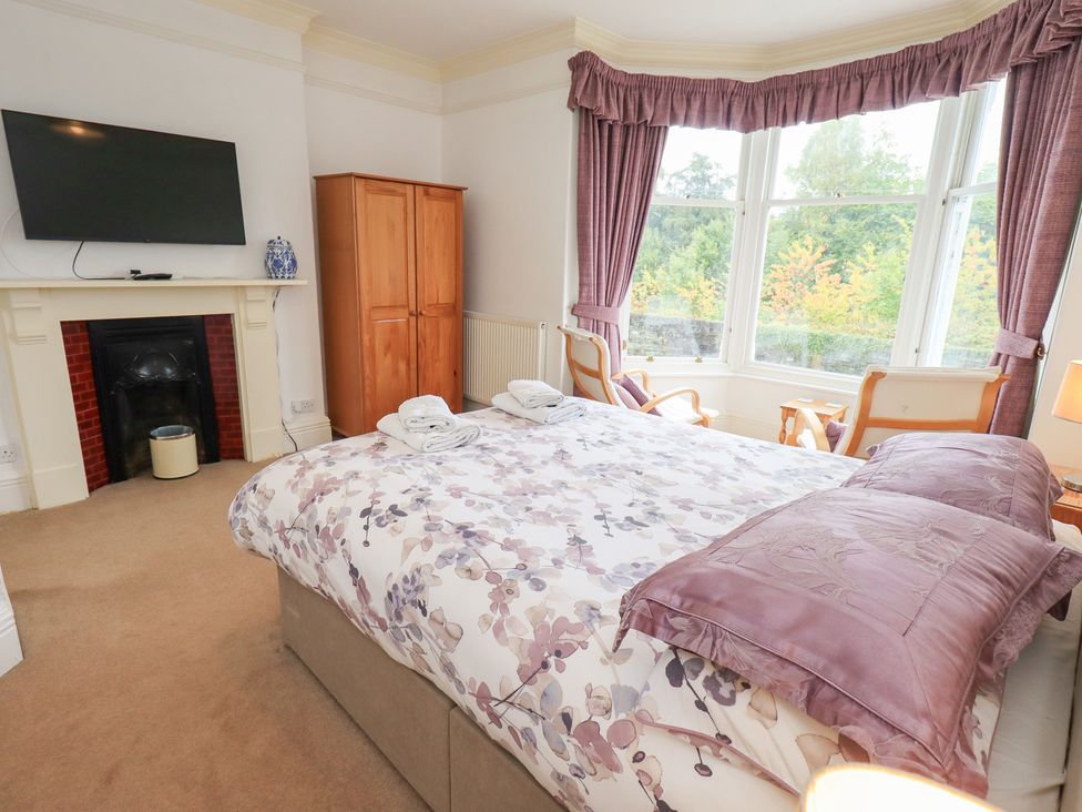 A bedroom with a bed, television, and wardrobe at Hazelmere in Keswick