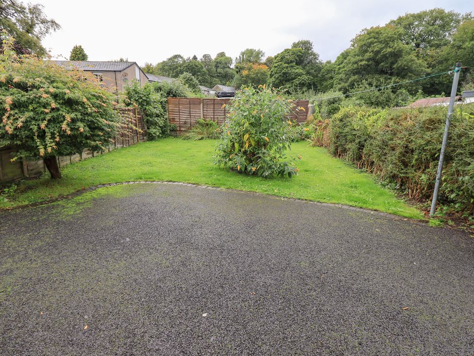 A garden with grass, trees, and a fence at Hazelmere in Keswick