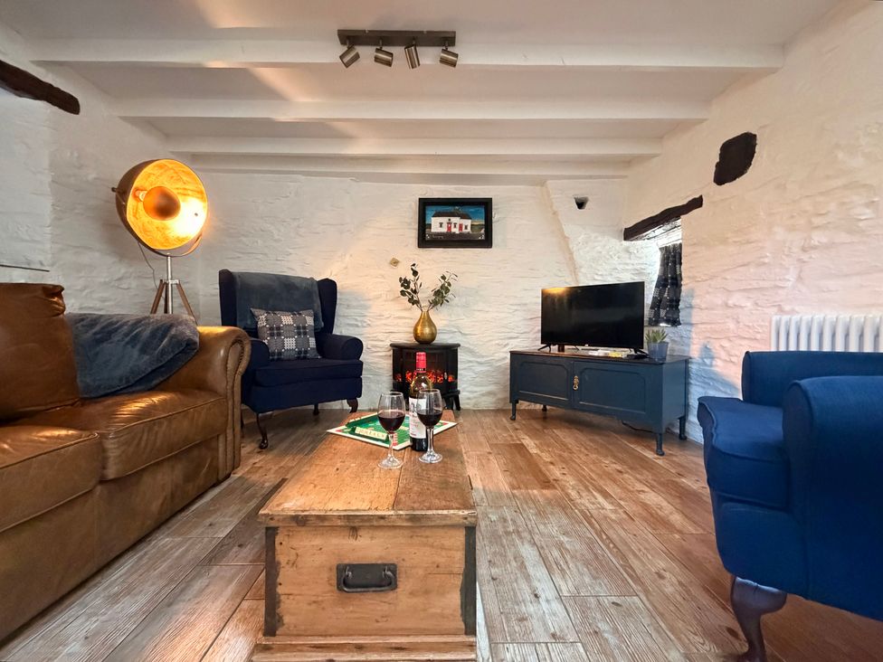 A living room with a sofa and armchairs at Pensarngerrig in Rhydlewis