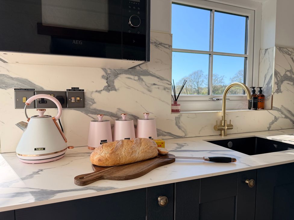 A kitchen with a kettle and bread on a cutting board at Pensarngerrig Rhydlewis