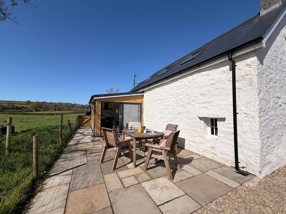 An outdoor area with a table and chairs at Pensarngerrig in Rhydlewis