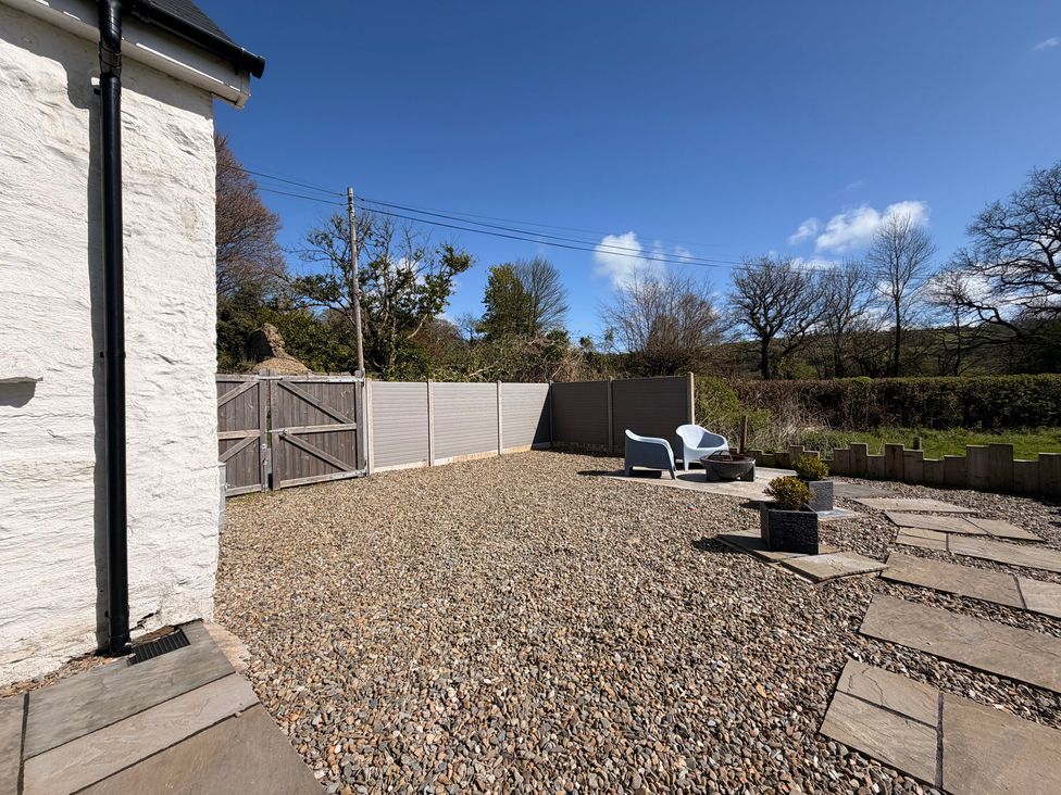 A garden with gravel and a seating area at Pensarngerrig in Rhydlewis