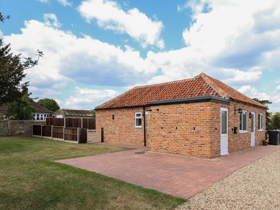 A brick house with windows and a patio at The Old Stables Folkingham