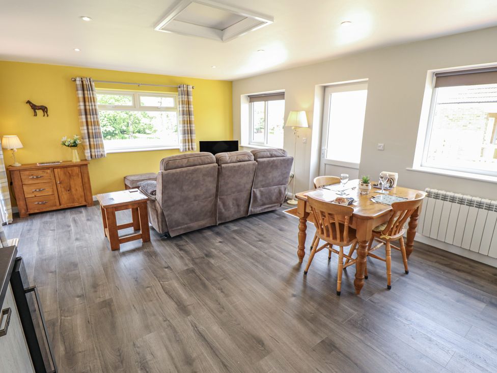A living room with a sofa and dining area at The Old Stables in Folkingham