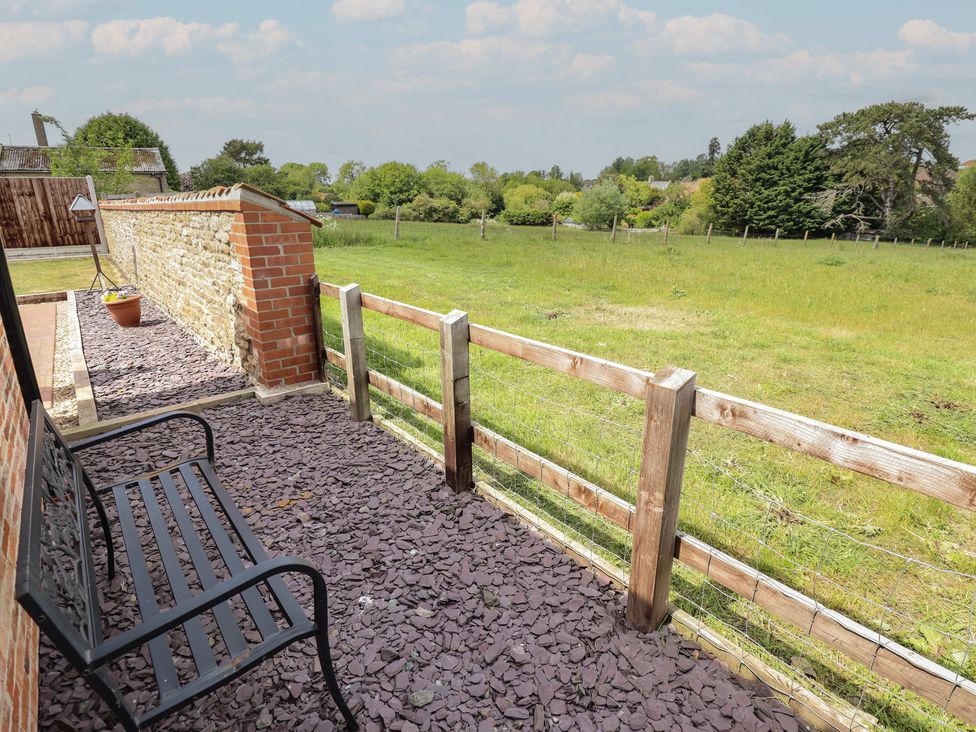 A garden area with a bench and fence at The Old Stables Folkingham