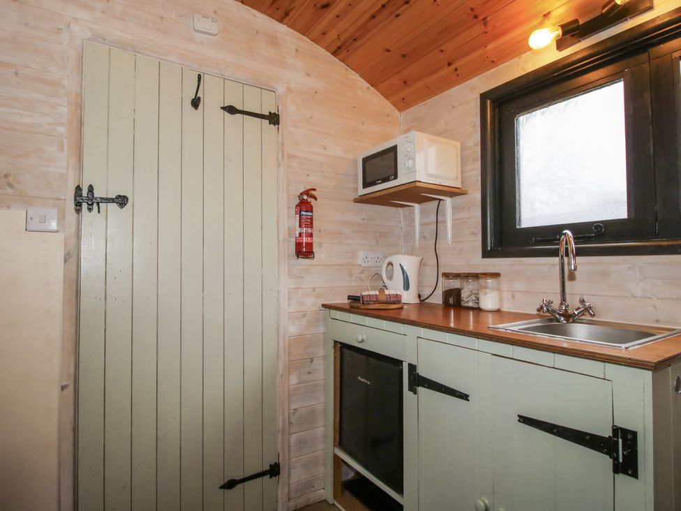 A kitchen with a sink and microwave at Aston - Shepherd Hut in Aston On Clun